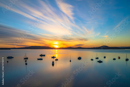 Aerial sunrise waterscape with boats and high cloud © Merrillie