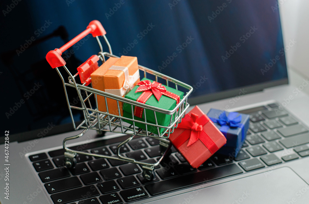 Black friday mini shopping bags in cart on the keyboard Online shopping ideas and home delivery services during the holidays.