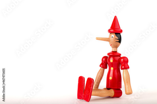 The concept of lies. Pinocchio's nose. Dishonest person caught being dishonest. Corruption, fake allegations, politicians. Wooden puppet. photo