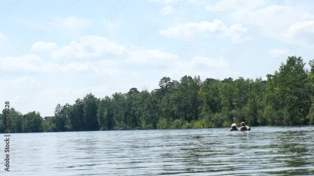Blurred view of mother with child floating, drifting by down the river, rafting. Having fun in travel, holidays concept. Happy family time outdoors. Slow motion Blurred view of mother with child floating, drifting by down the river, rafting. Having fun in travel, holidays concept. Happy family time outdoors. Slow motion