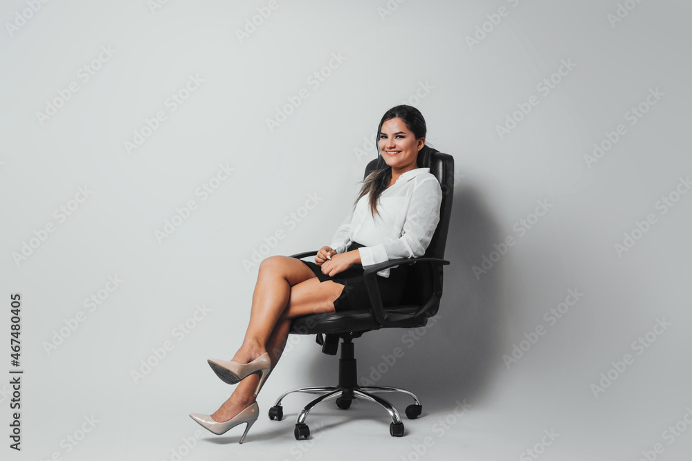 Full length of a business woman sitting on a chair over background. Full length of a business woman sitting on a chair over background.