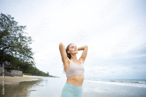 happy young woman enjoying freedom with open hands on sea. Happy woman smiling at the beach on a sunny day