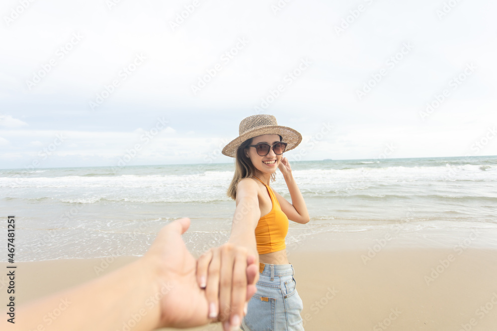 woman holding hand man. follow me concept. walking by sandy sea beach on sunset. Woman relaxing at beach enjoying summer freedom woman holding hand man. follow me concept. walking by sandy sea beach on sunset. Woman relaxing at beach enjoying summer freedom