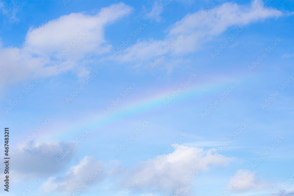 Blue sky with clouds and rainbow
