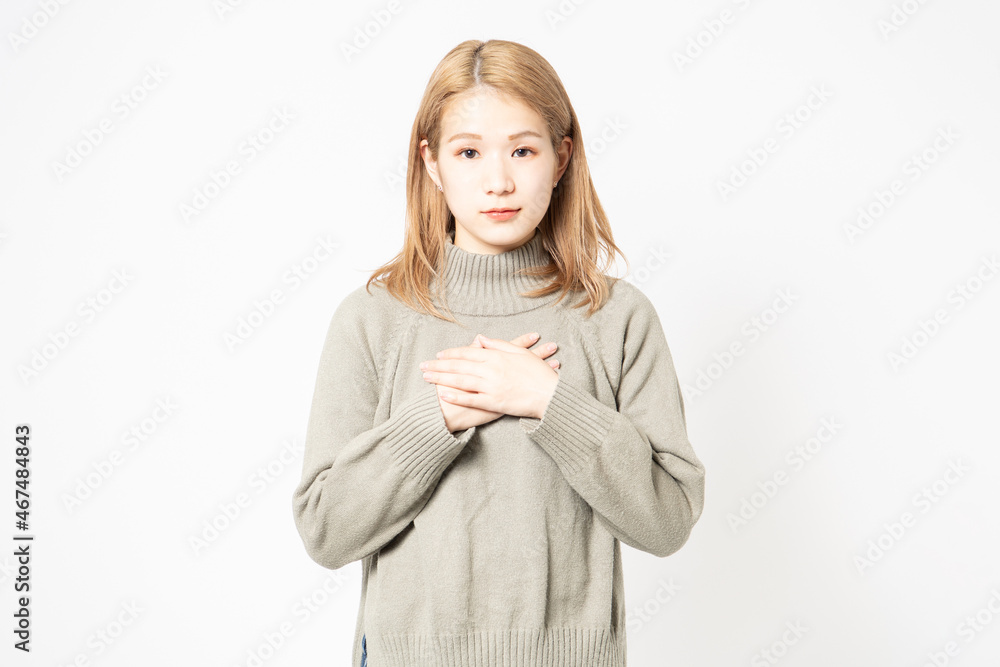 胸に手を当てるセーターを着た若い女性 胸に手を当てるセーターを着た若い女性
