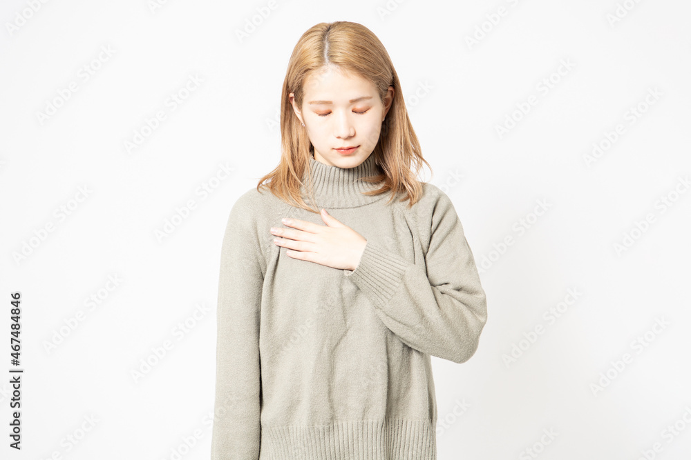 胸に手を当てるセーターを着た若い女性 胸に手を当てるセーターを着た若い女性