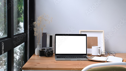 Mock up computer laptop, camera, books and coffee cup on wooden table.