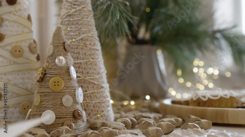 Christmas decotations on kithen table. Christmas gingerbread. New Year's sweety decorations, branches of a Christmas tree, fairy lights. photo