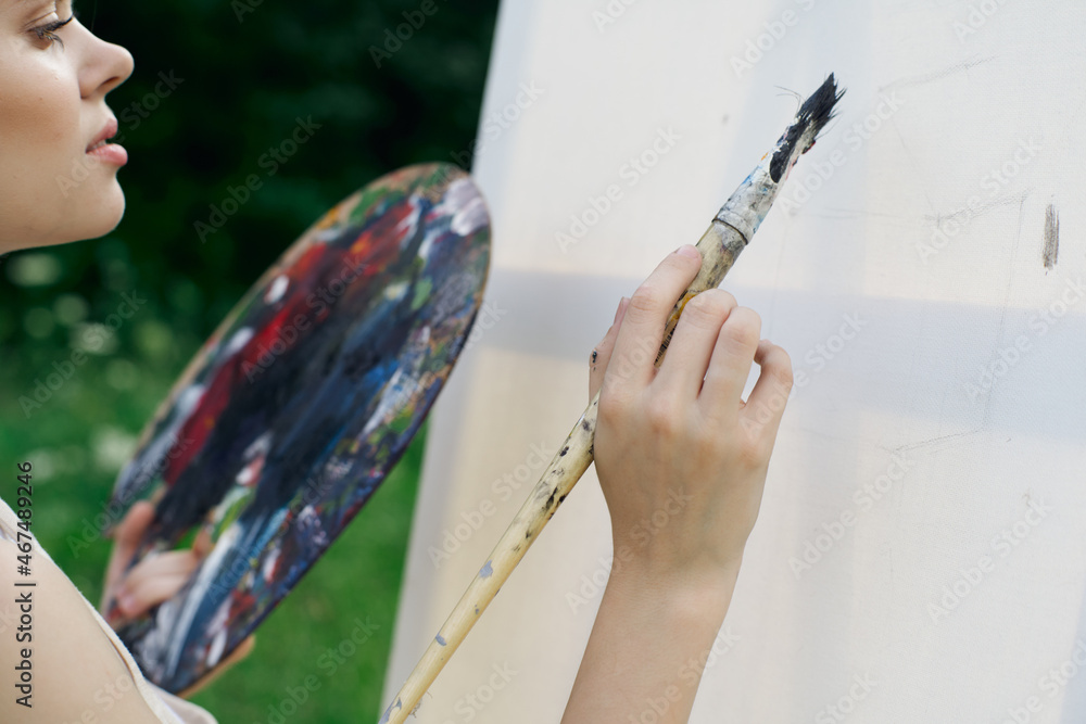 Obraz premium woman artist paints palette easel nature drawing