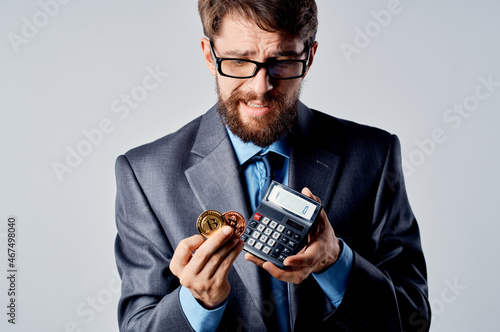 emotional man calculator bitcoin in hand counting finance studio official © SHOTPRIME STUDIO