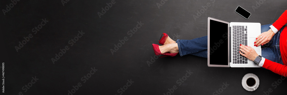 Woman working with laptop on dark floor, view from above, banner size - obrazy, fototapety, plakaty 