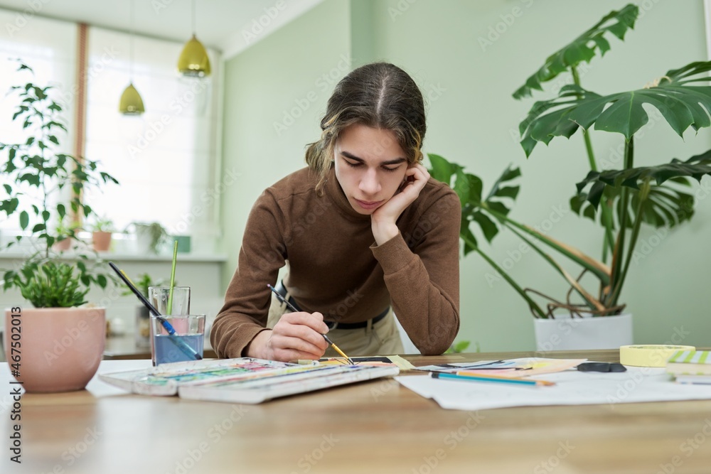 Teenager guy artist painting with watercolors at home Teenager guy artist painting with watercolors at home