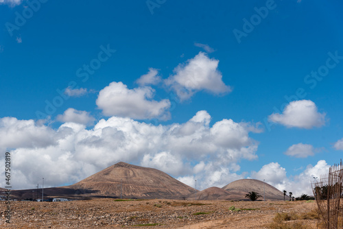 vista de unas montañas áridas de Lanazarote en las islas canarias con nubes blancas en un dia caluroso