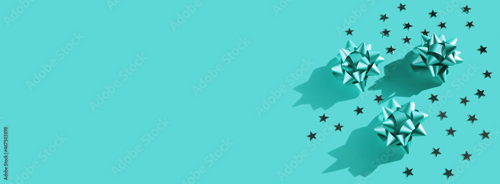 Gift bow with stars composition on monochrome background. Winter, sale and seasonal concept. Merry Christmas, New Year flat lay, top view. Space for text, banner