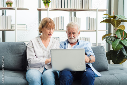 Senior woman teaching old man about laptop and he get confuse from technology.