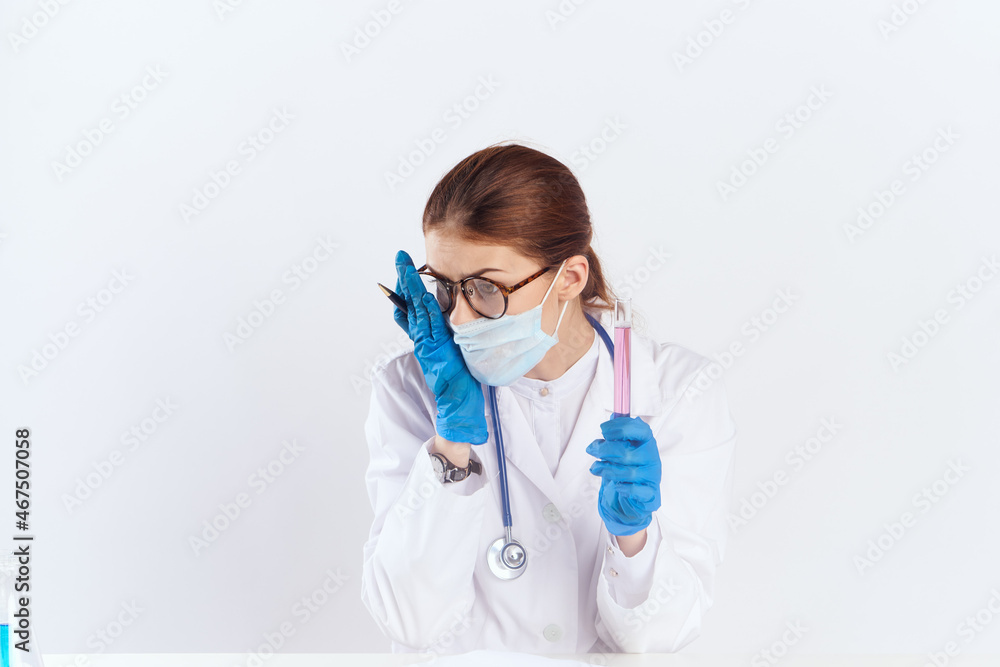 female doctor sitting at the table with blue gloves medication tests female doctor sitting at the table with blue gloves medication tests