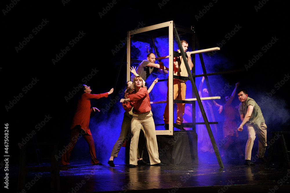 Actors and actresses perform a modern performance on the stage of the theater. - obrazy, fototapety, plakaty 