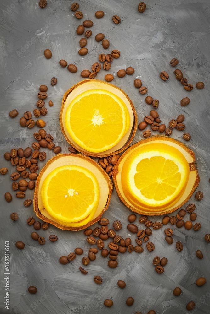 Juicy orange slices lie on three small wooden stands, roasted coffee beans around Juicy orange slices lie on three small wooden stands, roasted coffee beans around