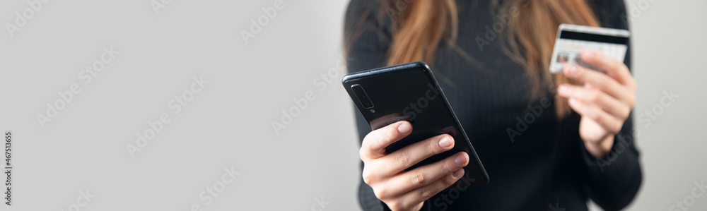 woman is holding credit card and smart phone