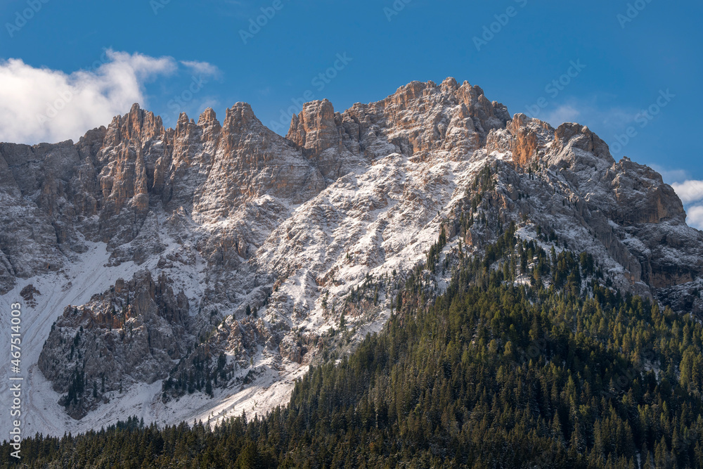 trees, mountain paths under the first snow on the lake of carezza in trentino alto adige in italy trees, mountain paths under the first snow on the lake of carezza in trentino alto adige in italy