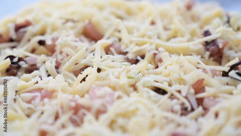 Raw pizza with bacon slices and cheese. Semi finished. Before baking. Close up Raw pizza with bacon slices and cheese. Semi finished. Before baking. Close up