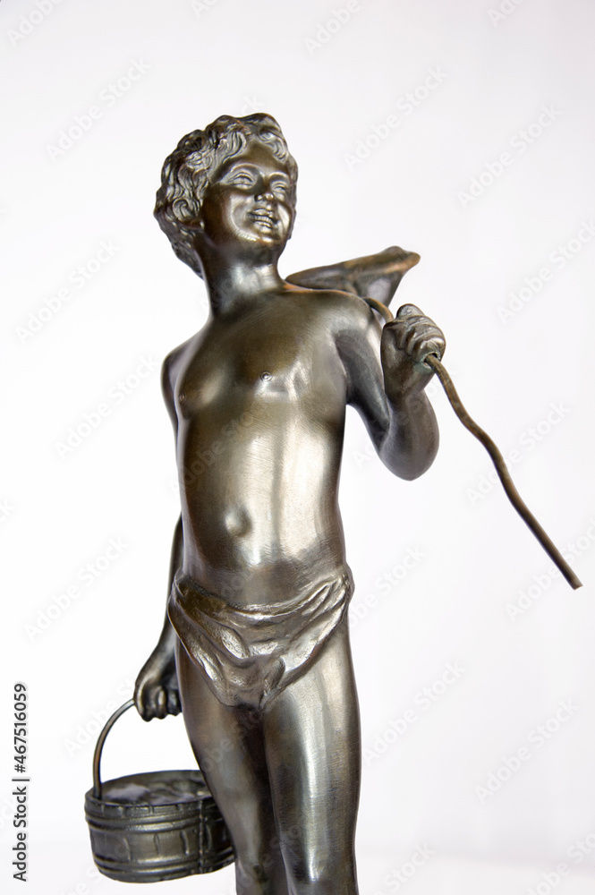 Details of a retro bronze statuette a boy with a crab net fishnet and basket isolated on white. Details of a retro bronze statuette a boy with a crab net fishnet and basket isolated on white.