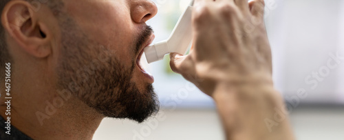 Fototapeta Naklejka Na Ścianę i Meble -  Man With Asthma Using An Asthma Inhaler