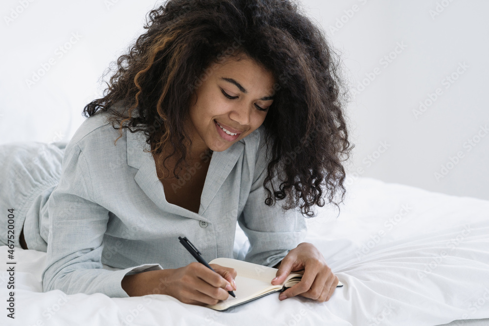 Afro american woman writes down information in notebook Afro american woman writes down information in notebook