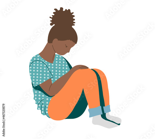 Young African-American girl, a teenager suffering from psychological illnesses, depression, anxiety , experiencing problems is sitting on the floor with her head down