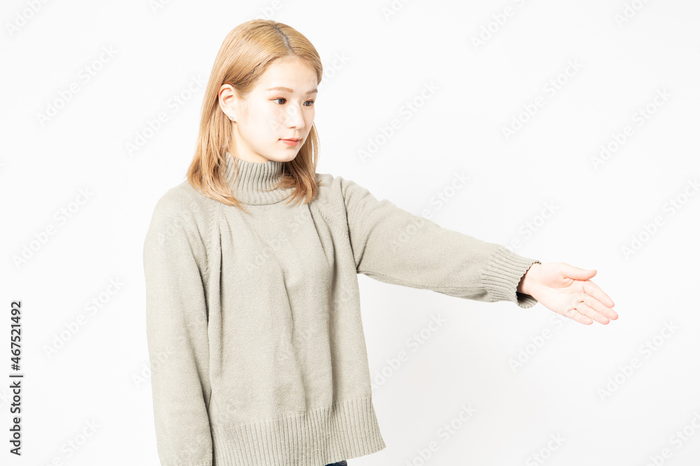 手を差し出すセーターを着た若い女性 手を差し出すセーターを着た若い女性