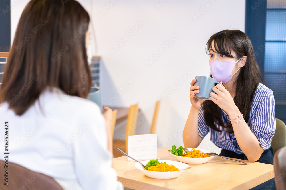 マスクをしてランチをする2人の若い女性