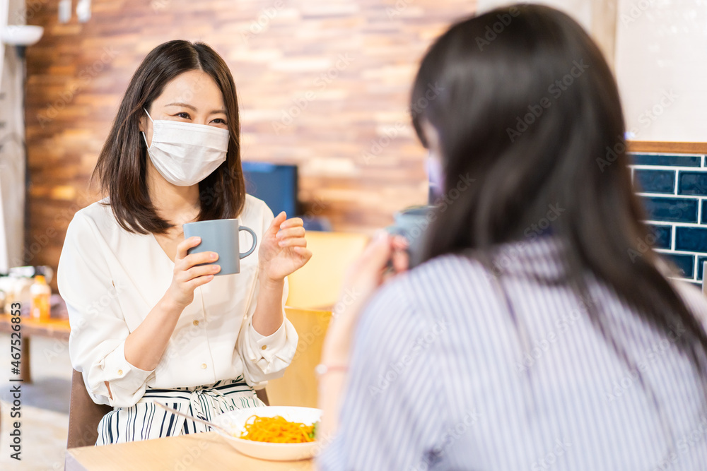 マスクをしてランチをする2人の若い女性