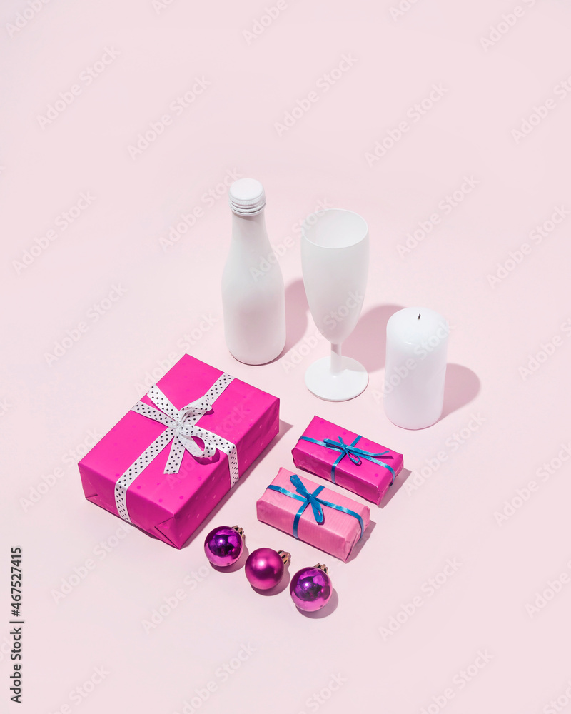 Christmas arrangement of white drinks and pink gifts and decorations on a pink background. Festive minimal composition.
