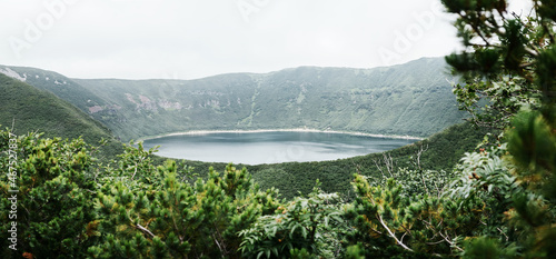 Small volcanic lake in the mouth of an inactive volcano in the forest. Bear bowl, Kamchatka