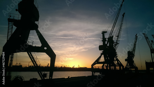 Silhouettes Of Port Cranes at sunset