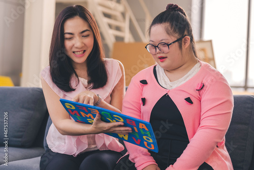 young girl with autism is practicing fun playing with toys at home with his mother. Autistic young students are learning with teachers happily.