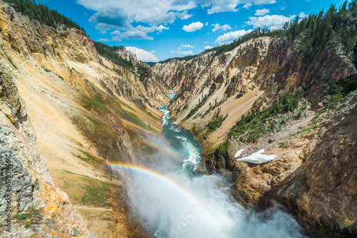 Rainbow over the waterfall. Amazing mountain landscape. Big waterfall among the beautiful rocks. Brink of the Lower Falls on the Grand Canyon of the Yellowstone, Yellowstone National Park, Wyoming