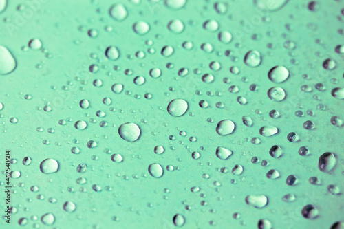 Lots of small oxygen bubbles under the water. Turquoise clear transparent liquid background and texture. Drops of water or rain on a green surface, natural abstract backdrop. Fresh mineral water.
