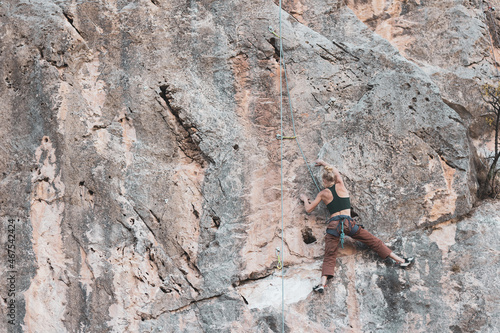 a girl climbing a rock in the open air.