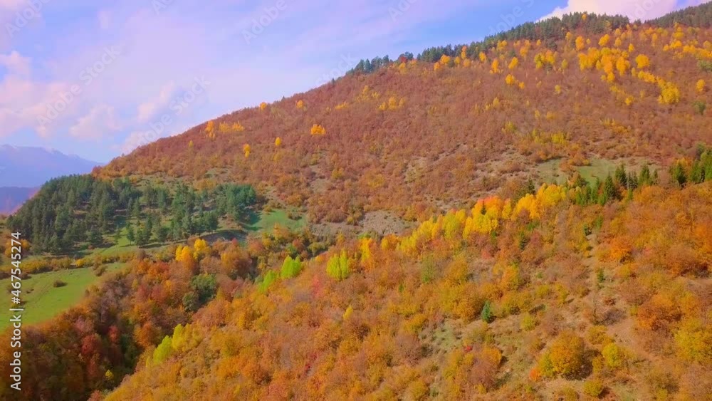 Epic aerial drone flight over mountains in autumn, sunset, colorful autumn trees, color of golden hour. Georgia, Svaneti region. Yellow, red and green leaves on trees. Colorful leaves in mountains. Epic aerial drone flight over mountains in autumn, sunset, colorful autumn trees, color of golden hour. Georgia, Svaneti region. Yellow, red and green leaves on trees. Colorful leaves in mountains.