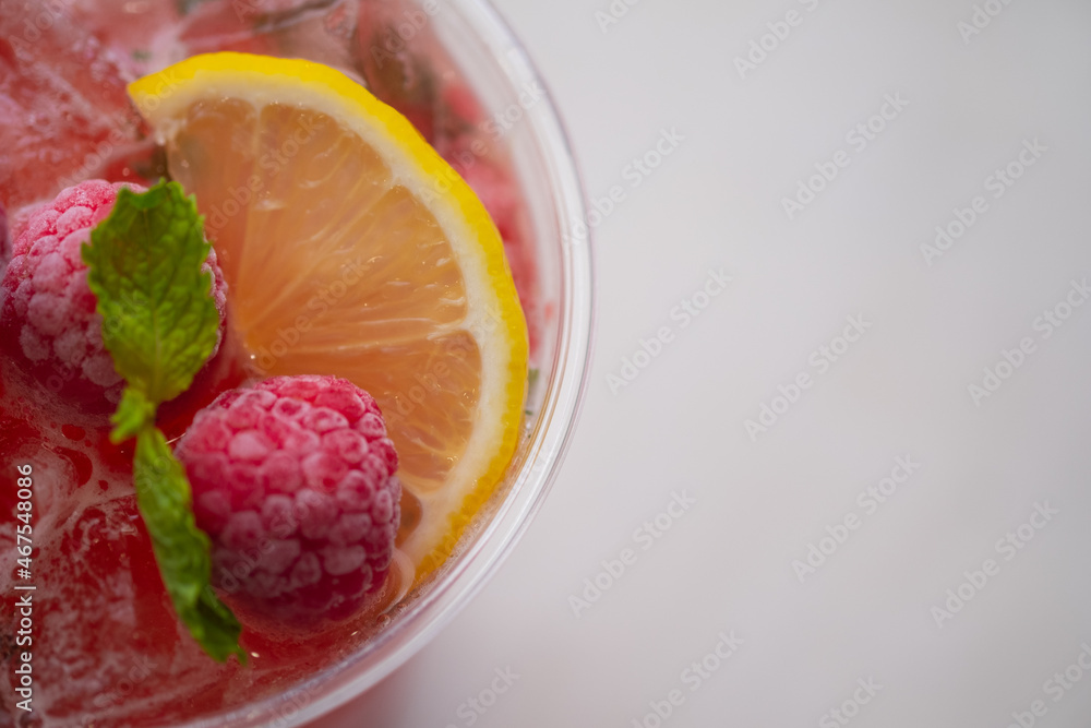 Summer refreshments in plastic glass decoration with slice lemon and berry Summer refreshments in plastic glass decoration with slice lemon and berry