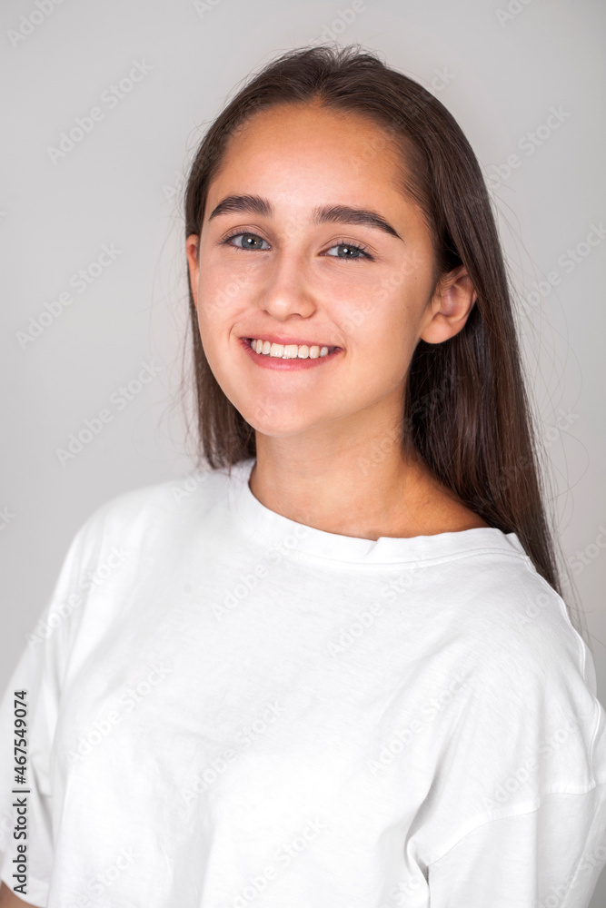 young beautiful happy brunette girl, isolated on gray background young beautiful happy brunette girl, isolated on gray background