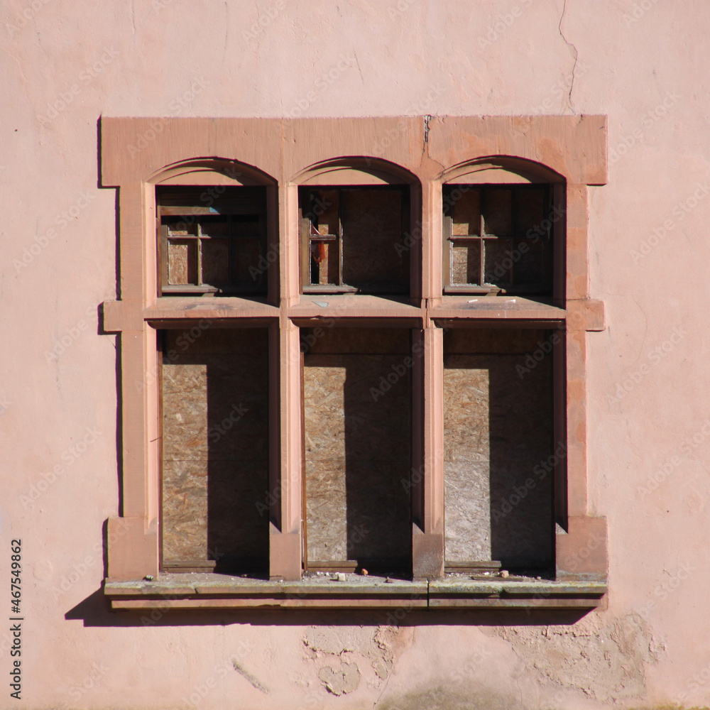 Naklejka premium Neo-renaissance nailed shut windows frames at the facade of an abandoned villa in the town of Trier Ehrang in Germany