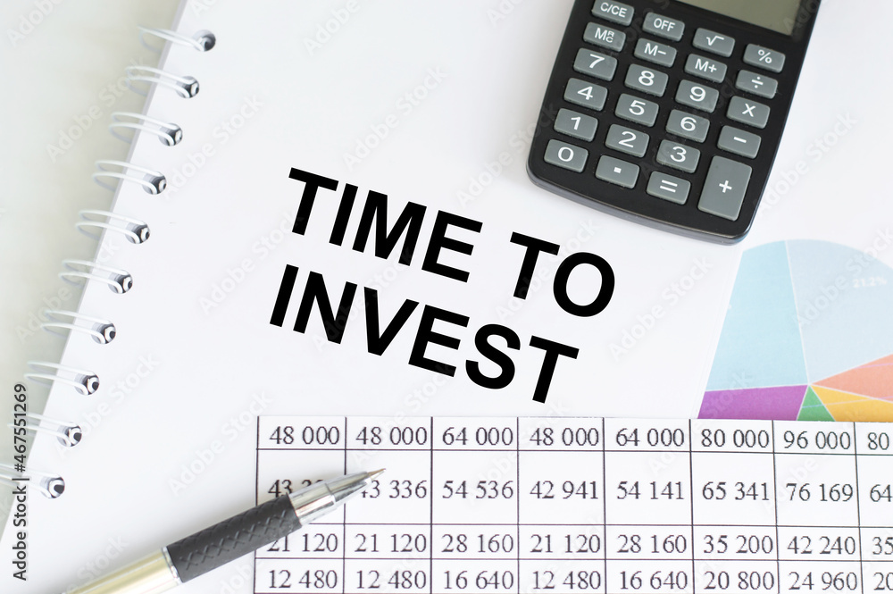 TIME TO INVEST text on paper with chart and office tools , business TIME TO INVEST text on paper with chart and office tools , business