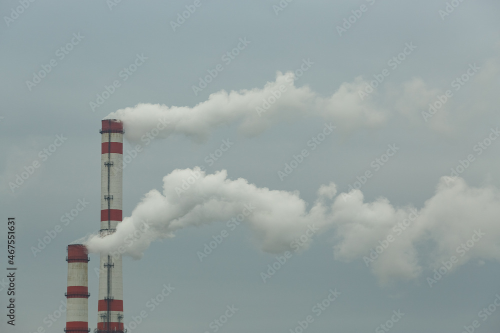 Smoke emanates from the chimney of an industrial enterprise, which pollutes the air.
