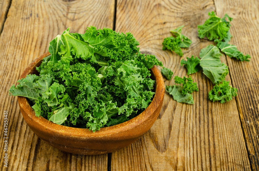 Fresh green sabellica leaves on wooden background, healthy organic food.
