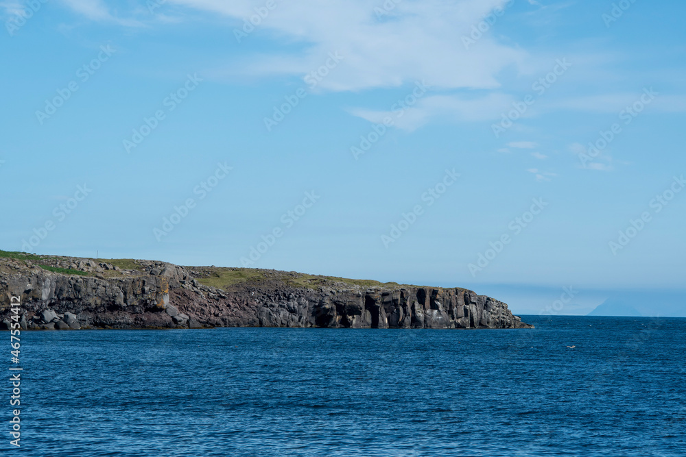 Landscape of cliffs rocky coast on sunny day in Keflavik Iceland