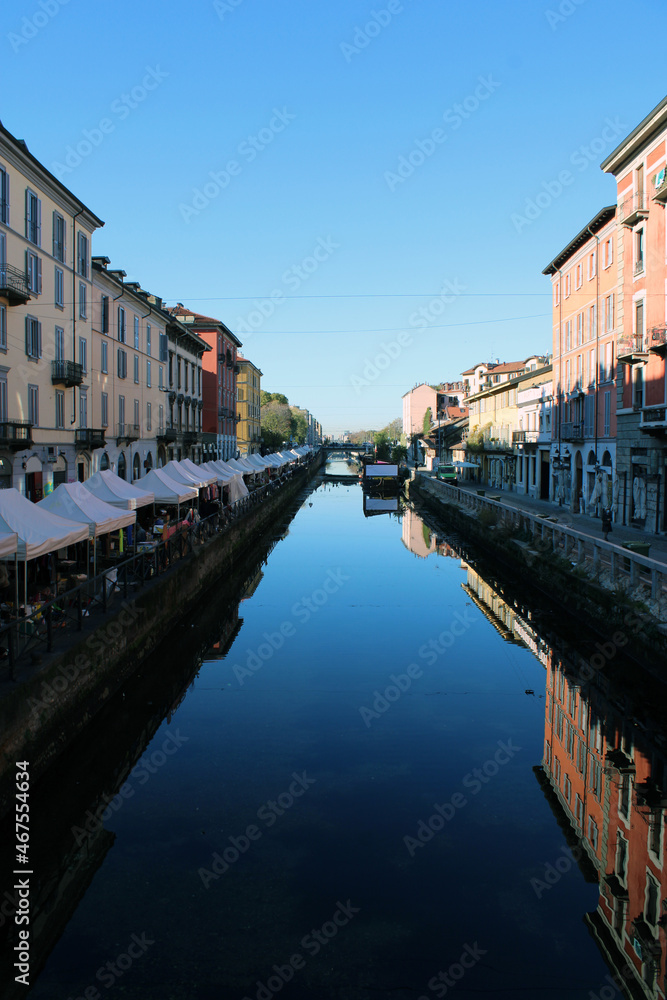 Naviglio Grande di Milano con bancarelle e riflessi nell'acqua