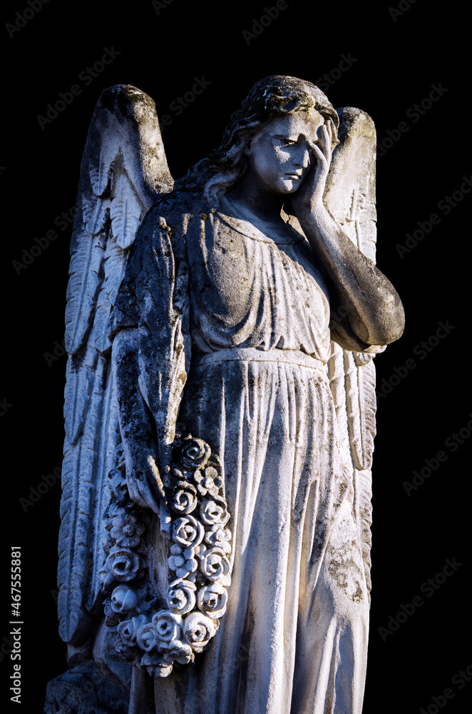 An ancient sculpture of a sad angel mourning the dead, on a tragic background.