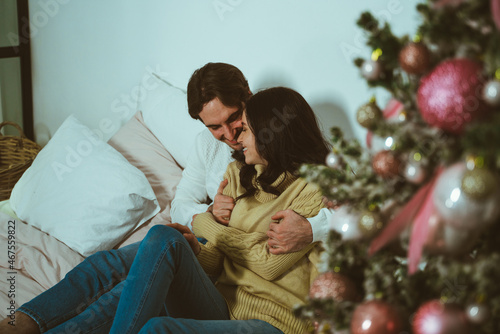Cinematic image of a couple celebrating christmas at home. © oneinchpunch